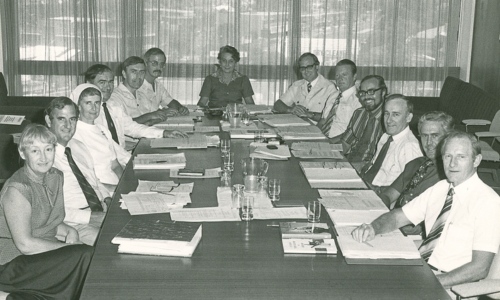 Archived image of board members at desk